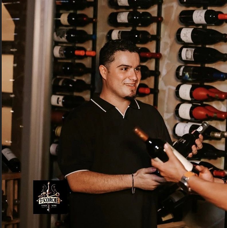 Gustavo en la cava de D’SCORCHE sosteniendo una botella